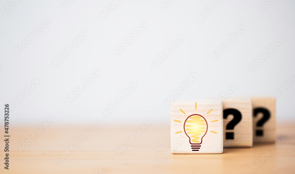Poster drawing glowing lightbulb in front of question mark which print on wooden cube block for question an