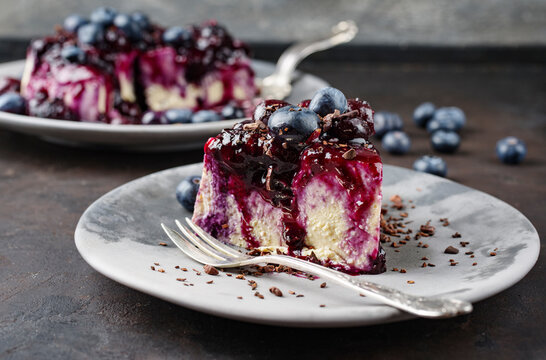 Traditional blueberry cheesecake with fresh berries, compote and chocolate crumbles served as close-up on a design plate