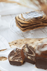 Chocolate marble loaf cake with chocolate glaze. On white cafe table.