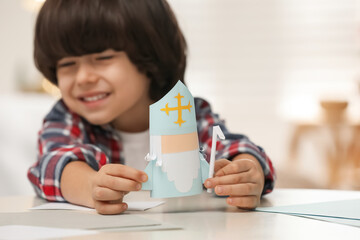 Cute little boy with paper Saint Nicholas toy at home, focus on hands