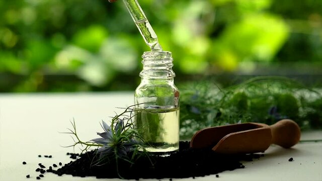 Black cumin oil in a bottle. Selective focus.