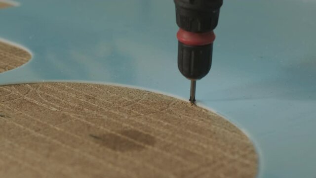 Production of advertising signs in the factory. Screwdriver tightens the screw
