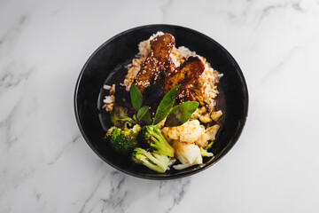 vegan marinated teriyaki tempeh withsteamed broccoli and coauliflower on a bed of white coconut rice, healthy plant-based food