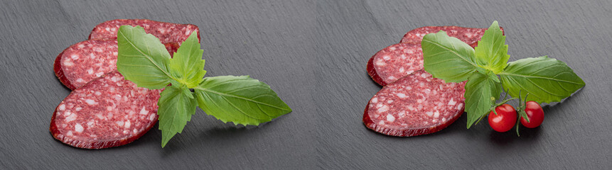 Slices of smoked sausage with fresh herbs on a black cutting board