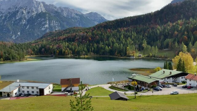 Panning shot of Lauter Lake with inns and peaks of the Karwendel mountains in the background, very close to the bavarian town of Mittenwald in Germany