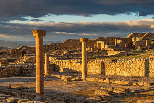 Pillars and ruins of the ancient city of Bargala at sunset (Golden Hour). Dramatic scene.