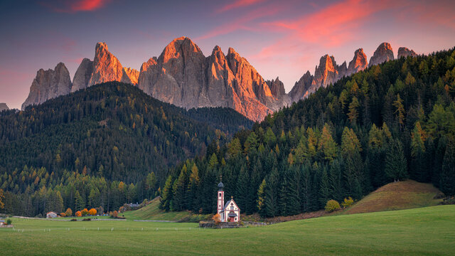Autumn in Alps. Panoramic image of  magical Dolomites mountains in a gorgeous Val di Funes valley,  South Tyrol, Italian Alps at autumn sunset.