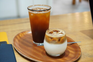 Ice latte in glass and ice Americano in glass on a wooden table. Cafe in south Korea.