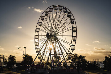 Ferris Wheel on the Beach at Sunset with Golden Sun Rays