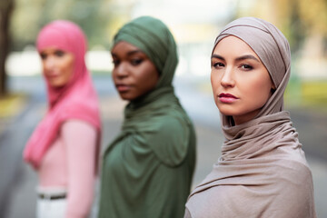 Three Serious Young Muslim Ladies Posing Looking At Camera Outdoors