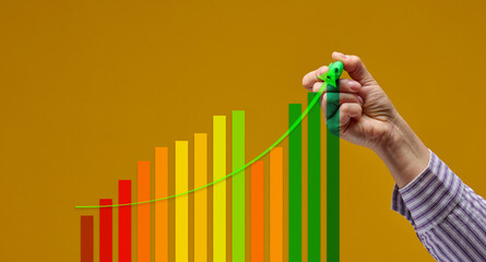 female hand with green marker and multicolored graph on yellow background. Performance growth concept, positive dynamics