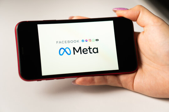 META logo on smartphone being held in hand in front of phone with Facebook icon. Facebook changes company name to Meta and focuses on Metaverse in its rebrand. Los Angeles, California, USA - January 