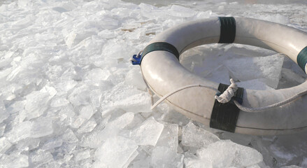 A lifebelt on the ice swimming spot at wintery beach and shards of ice