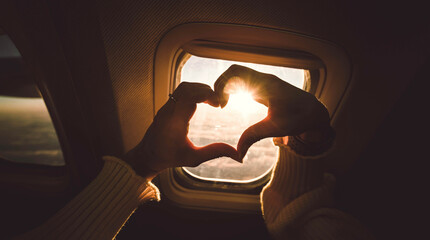 Tourist woman making heart shape with hands in airplane - Travel addicted concept with female enjoying vacation - Travel, holidays and love concept - obrazy, fototapety, plakaty