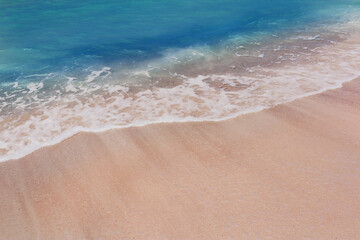 The foam formed by the waves crashing on the beach, the beautiful sea color