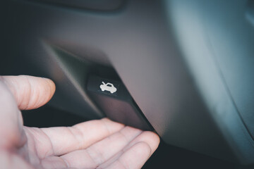 Mechanic's hand pulling car bonnet release lever