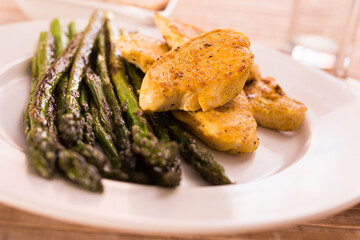cooked dish. Chicken nuggets with green asparagus on plate