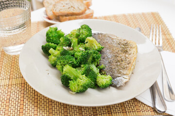 dish of fried dorado fish fillet with boiled broccoli