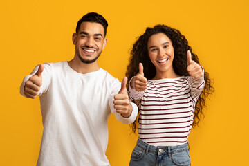 Best Choice. Portrait of happy middle-eastern couple gesturing thumbs up at camera