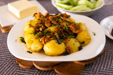 baked potatoes with chanterelles, served with herbs on white plate