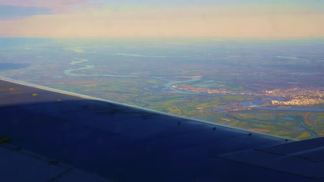 The Plane Flies Up To A Small Town On The River Bank. View From The Plane's Eluminator To The Hometown, Which Has Not Been For A Long Time, Returning Home By Plane. Flight By Plane On Vacation.