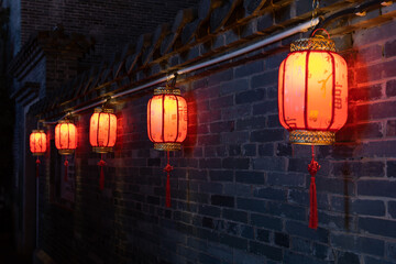 Under the eaves of the ancient city wall, lanterns with Chinese blessings are hung
