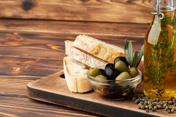 Italian ciabatta bread with olive oil on wooden background