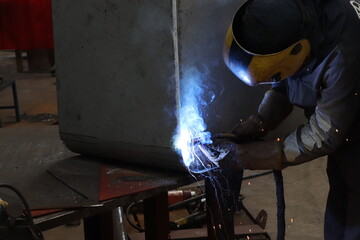 The man welding in the factory