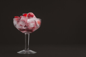 Wine glass with cherry juice against a black background