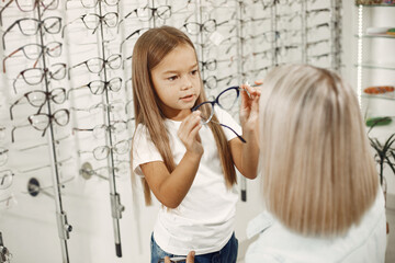 Family choosing glasses at optics store