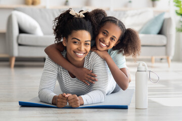 Portrait of athletic black mother and daughter bonding while exercising