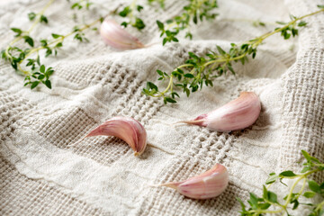 cloves of garlic and fresh thyme on a light table