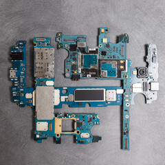 The inside of the smartphone's motherboard and tools lay on the back table. the concept of computer...