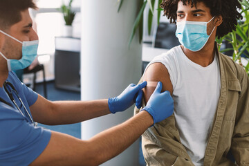 Black Guy Getting Vaccinated Against Covid-19, Doctor Applying Plaster