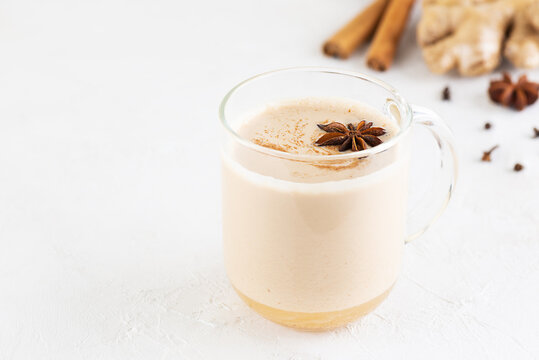 Vegan masala tea with coconut milk and spices in a glass mug. Selective focus. Horizontal orientation, copy space.