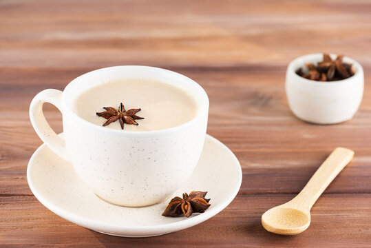 Masala tea with spices in a mug on a wooden table. Lactose free, vegan. Selective focus.