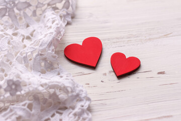 Obraz na płótnie Canvas Two red hearts on a white wooden background. Valentine's Day