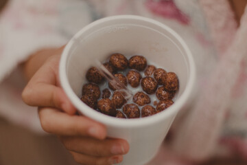 chocolate cornflakes with milk on a white cup