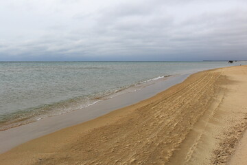 winter the deserted sandy beach goes over the horizon