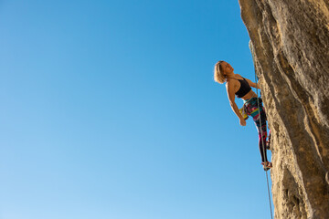 The girl climbs the rock.