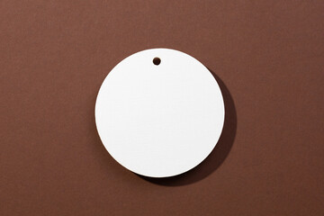 One white colored cardboard brand blank tag of circle shape with little hole in upper part...