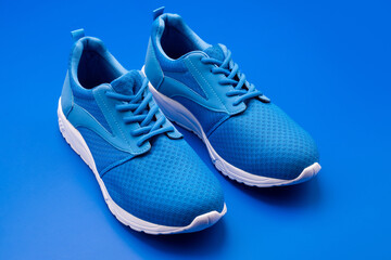 sporty blue sneakers pair on blue background, shoes