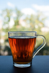 Mug of black tea by the window close up