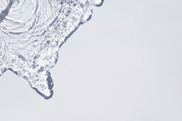 Rippled water light blue backdrop. Background with sun reflection for cosmetic concept. Transparent blue trendy banner with place for text. Micellar water or toner texture