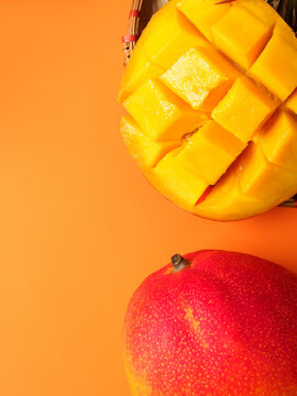 Delicious ripe mango sliced ​​ready to eat. Isolated on a colored background. Food frame, summer, tropical fruits, exotic. Space for text. Close up, top veiw. Juicy mango with palm leaves. Diet fruit