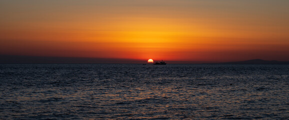 Silhouette of boat on sea beach with sunset background. Sunset moment at the sea side in Neos Marmaras, Greece.