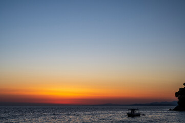 Silhouette of boat on sea beach with sunset background. Sunset moment at the sea side in Neos Marmaras, Greece.