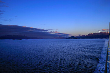 Amazing and breathtaking full moon scenery over Patagonia during early morning with city of...