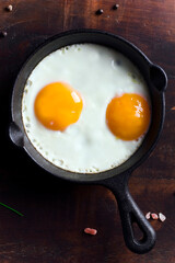Fried eggs in a pan on a wooden table