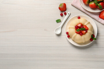 Delicious semolina pudding with berries on white wooden table, flat lay. Space for text